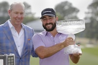 Jim Crane, left, owner of the Houston Astros baseball team, and Stephan Jaeger pose for photos with the trophy during ceremonies after Jaeger's win after the final round of the Houston Open golf tournament Sunday, March 31, 2024, in Houston. (AP Photo/Michael Wyke)
