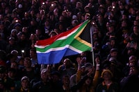 South African rugby fans wave a South African national flag ahead of the France 2023 Rugby World Cup Final match between New Zealand and South Africa at the Stade de France in Saint-Denis, on the outskirts of Paris, on October 28, 2023. (Photo by Anne-Christine POUJOULAT / AFP) (Photo by ANNE-CHRISTINE POUJOULAT/AFP via Getty Images)