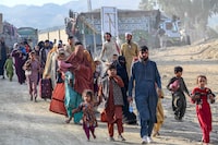 Afghan refugees in Pakistan walk towards the Pakistan-Afghanistan Torkham border on November 3, 2023, following Pakistan's government decision to expel people illegally staying in the country. More than 165,000 Afghans have fled Pakistan since Islamabad issued an ultimatum to 1.7 million people a month ago to leave or face arrest and deportation, officials said on November 2. (Photo by Abdul Majeed AFP photographer / AFP) (Photo by ABDUL MAJEED AFP PHOTOGRAPHER/AFP via Getty Images)