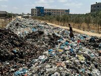 A Palestinian man walks on piles of garbage, amid the ongoing conflict in Gaza between Israel and Hamas, at Deir Al-Balah, in the central Gaza Strip, May 2, 2024. REUTERS/Doaa Rouqa     TPX IMAGES OF THE DAY