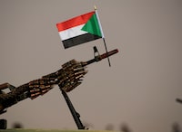 FILE PHOTO: A Sudanese national flag is attached to a machine gun of Paramilitary Rapid Support Forces (RSF) soldiers as they wait for the arrival of Lieutenant General Mohamed Hamdan Dagalo, deputy head of the military council and head of RSF, before a meeting in Aprag village 60, kilometers away from Khartoum, Sudan, June 22, 2019. REUTERS/Umit Bektas/File Photo