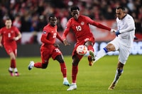 Canada forward Jonathan David (10) and Honduras defender Devron Garcia (2) battle for the ball during second half CONCACAF Nations League soccer action in Toronto on Tuesday, March 28, 2023. THE CANADIAN PRESS/Nathan Denette