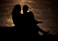 A couple is silhouetted against moonlight reflecting off the Missouri River as they watch the full moon rise beyond downtown buildings in Kansas City, Mo. June 27, 2018. According to insurance tech company Zelros, younger people are less likely to have life insurance, with just over half of those aged 18-34 covered by life insurance. But experts say the decision about whether to get life insurance isn’t about how old you are. THE CANADIAN PRESS/AP/Charlie Riedel