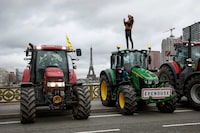 French farmers of the Coordination Rural (CR) use their tractors during a go-slow operation on the Pont Mirabeau bridge with the Eiffel Tower in the background as they protest ahead of the opening of the Paris farm show, in Paris, France, February 23, 2024. REUTERS/Benoit Tessier     TPX IMAGES OF THE DAY