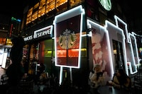 File - People drink coffee outside a Starbucks at a shopping mall in Beijing on Dec. 23, 2023. Starbucks on Tuesday reported record revenue in its fiscal first quarter but the results fell short of Wall Street's expectations as customer spending slowed in some key markets. (AP Photo/Andy Wong)