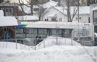 A city bus is shown next to a daycare centre in Laval, Que, Wednesday, Feb. 8, 2023. The case of a Quebec man accused of killing two young children by driving a city bus into a Montreal-area daycare has been postponed to late August. THE CANADIAN PRESS/Graham Hughes