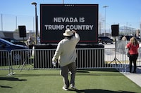FILE - A person takes a picture of a screen before Republican presidential candidate former President Donald Trump speaks at a campaign event Jan. 27, 2024, in Las Vegas. (AP Photo/John Locher, File)