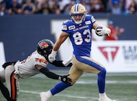 Winnipeg Blue Bombers' Dalton Schoen (83) escapes the tackle by B.C. Lions' T.J. Lee (6) to run the ball in for a touchdown during first half CFL action in Winnipeg Thursday, August 3, 2023. Dalton Schoen is confident he didn’t make a mistake by re-signing with the Winnipeg Blue Bombers. THE CANADIAN PRESS/John Woods