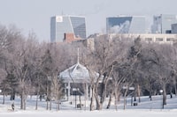 A man and a dog walk the path around Wascana Lake, flanked by downtown Regina on Thursday Feb. 18, 2021. An agency responsible for tourism in Regina has apologized for using slogans that have been criticized for their sexual overtones. THE CANADIAN PRESS/Michael Bell