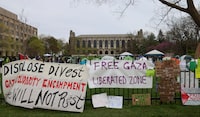 Signs are displayed outside a tent encampment at Northwestern University on Friday, April 26, 2024, in Evanston, Illinois. Students want the university to divest from funds connected to Israel or that profit from its war in Gaza. (AP Photo/Teresa Crawford)