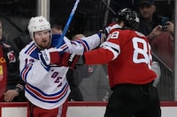 New York Rangers' Alexis Lafrenière, left, and New Jersey Devils' Kevin Bahl scuffle during the third period of Game 2 of an NHL hockey Stanley Cup first-round playoff series in Newark, N.J., Thursday, April 20, 2023. The Rangers won 5-1. (AP Photo/Seth Wenig)