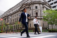 People walk in front of the bank of Japan building in Tokyo, Japan, April 7.