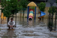 A Pakistani sits beside a flooded park caused by heavy rain in Peshawar, Pakistan, Monday, April 15, 2024. Lightening and heavy rains killed dozens of people, mostly farmers, across Pakistan in the past three days, officials said Monday, as authorities declared a state of emergency in the country's southwest following an overnight rainfall to avoid any further casualties and damages. (AP Photo/Muhammad Sajjad)