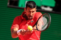 Serbia's Novak Djokovic plays a backhand return to Italy's Lorenzo Musetti during their Monte Carlo ATP Masters Series Tournament round of 16 tennis match on the Rainier III court at the Monte Carlo Country Club on April 11, 2024. (Photo by Valery HACHE / AFP) (Photo by VALERY HACHE/AFP via Getty Images)