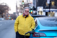 Daniel Breton, CEO of Electric Mobility Canada, plugs in on Montreal’s Plateau-Mont-Royal on Dec. 14, 2023. He says more education is needed about the long-term cost of owning and electric vehicle.