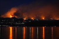 The McDougall Creek wildfire burns on the mountainside above lakefront homes in West Kelowna, B.C., on Friday, Aug. 18, 2023. THE CANADIAN PRESS/Darryl Dyck