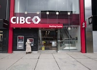 A person using the atm at a new branch of the CIBC on Queen St. West near Spadina Ave., is photographed on March 14.23. Ontario, (Fred Lum/The Globe and Mail)