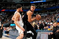 Denver Nuggets forward Michael Porter Jr. (1) and Phoenix Suns guard Devin Booker (1) in the second half of an NBA basketball game Wednesday, March 27, 2024, in Denver. (AP Photo/David Zalubowski)