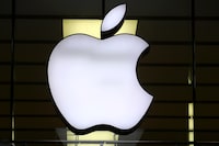 FILE - The Apple logo is illuminated at a store in the city center of Munich, Germany, Dec. 16, 2020. European Union fines Apple nearly $2 billion for unfairly favoring its own music streaming service over rivals. (AP Photo/Matthias Schrader, File)