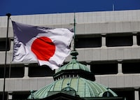 FILE PHOTO: The Japanese national flag waves at the Bank of Japan building in Tokyo, Japan March 18, 2024. REUTERS/Kim Kyung-Hoon/File Photo