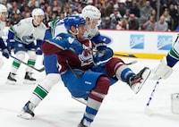 Colorado Avalanche right wing Mikko Rantanen, front, and Vancouver Canucks defenseman Tyler Myers tangle during the third period of an NHL hockey game Wednesday, Nov. 22, 2023, in Denver. (AP Photo/David Zalubowski)