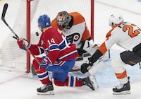 Montreal Canadiens' Nick Suzuki (14) scores on Philadelphia Flyers goaltender Samuel Ersson (33) as Flyers' Ronnie Attard (23) tries to defend during first period NHL hockey action in Montreal on Thursday, March 28, 2024. THE CANADIAN PRESS/Christinne Muschi