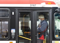 A TTC worker wears a mask in a bus while on shift in Toronto on April 23, 2020.&nbsp;The Toronto Transit Commission has placed a firm order for 110 low-floor transit buses with the subsidiary of NFI Group for an undisclosed price.&nbsp;THE CANADIAN PRESS/Nathan Denette