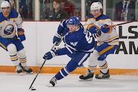 Toronto Maple Leafs' Easton Cowan is checked by Buffalo Sabres' Norman Ponacha during the third period of the Kraft Hockeyville pre-season game between the Sabres and the Leafs at the Joe Thornton Community Centre in St. Thomas, Ont., Wednesday, Sept. 27, 2023. THE CANADIAN PRESS/Geoff Robins