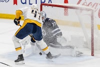 Winnipeg Jets goaltender Connor Hellebuyck (37) saves the breakaway shot from Nashville Predators' Michael McCarron (47) during first period NHL action in Winnipeg on Wednesday, March 13, 2024. THE CANADIAN PRESS/John Woods