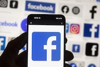The Facebook logo is seen on a cell phone, on Oct. 14, 2022, in Boston. The company that owns the Toronto Star says it's pausing all advertising on Facebook and Instagram. THE CANADIAN PRESS/AP-Michael Dwyer