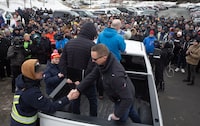 John Efford Jr. shakes hands with a fellow harvester as FFAW Secretary-Treasurer, Jason Spingle addresses the fish harvesters gathered outside the Confederation Building in St. John's, Friday, March 22, 2024. A pricing agreement has been reached between crab fishers and seafood processors that will allow for Newfoundland and Labrador's annual crab fishery to get started. THE CANADIAN PRESS/Paul Daly