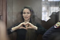 Antonina Favorskaya stands in a glass cage in a courtroom in the Basmanny District Court in Moscow, Russia, Friday, March 29, 2024. A court in Moscow makes a decision on measure of restrain to journalist Antonina Favorskaya in the case of her connection with the FBK, the Anti-Corruption Foundation set up by Russian opposition leader Alexei Navalny in 2011 and declared extremist and closed in 2021. (AP Photo/Dmitry Serebryakov)