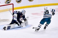 San Jose Sharks' Logan Couture (39) scores on Winnipeg Jets goaltender David Rittich (33) during overtime in NHL action in Winnipeg on Monday March 6, 2023. THE CANADIAN PRESS/Fred Greenslade