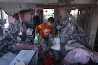 A Palestinian child salvages belongings from the rubble of a house hit by overnight Israeli bombing in Rafah in the southern Gaza Strip on April 20, 2024, amid the ongoing conflict between Israel and the Hamas movement. (Photo by AFP) (Photo by -/AFP via Getty Images)