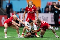 Canada's Krissy Scurfield, right, takes down New Zealand's Risi Pouri-Lane as Canada's Olivia Apps, left, and Caroline Crossley watch during Vancouver Sevens women's rugby semifinal action, in Vancouver, on Sunday, Feb. 25, 2024. Fifth-ranked Canada has been drawn with No. 1 New Zealand, No. 7 Ireland and No. 12 Spain in Pool A in women's play at the Singapore Sevens. THE CANADIAN PRESS/Ethan Cairns