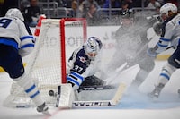 Dec 13, 2023; Los Angeles, California, USA; Winnipeg Jets goaltender Connor Hellebuyck (37) blocks a shot as Los Angeles Kings defenseman Matt Roy (3) moves in for the rebound during the second period at Crypto.com Arena. Mandatory Credit: Gary A. Vasquez-USA TODAY Sports