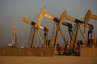 An array of pumpjacks operate near the site of a new oil and gas well being drilled Friday, April 8, 2022 in Midland, Texas. Exxon Mobil Corp. is buying Pioneer Natural Resources in an all-stock deal valued at $59.5 billion, its largest buyout since acquiring Mobil two decades ago, creating a colossal fracking operator in West Texas. (Eli Hartman/Odessa American via AP, File)