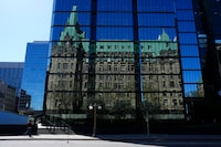 The Confederation building on Parliament Hill is reflected in the windows of the Bank of Canada in Ottawa on Monday, May 6, 2024. THE CANADIAN PRESS/Sean Kilpatrick

