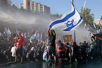 Israeli security forces use a water cannon to disperse demonstrators blocking the entrance of the Knesset, Israel's parliament, in Jerusalem on July 24, 2023, amid a months-long wave of protests against the government's planned judicial overhaul. Israeli lawmakers on July 24 prepared for a final vote on a major component of the hard-right government's controversial judicial reforms even as US President Joe Biden called for postponing the "divisive" bill that has triggered mass protests. (Photo by RONALDO SCHEMIDT / AFP) (Photo by RONALDO SCHEMIDT/AFP via Getty Images)