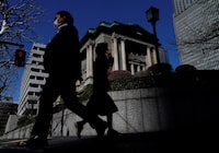 Pedestrians walk past the Bank of Japan building in Tokyo, March 18, 2024.