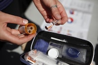 New guidance, led by the BC Centre for Disease Control (BCCDC), aims to standardize take-home naloxone kits that are distributed through various sites including pharmacies, community groups and hospitals to anyone who could respond to an overdose. An organizer displays a naloxone kit that people can pick up for free, in Victoria, Saturday, Aug. 31, 2019. THE CANADIAN PRESS/Chad Hipolito