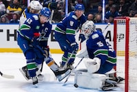 Vancouver Canucks goaltender Thatcher Demko (35) stops St. Louis Blues' Robert Thomas (18) as Vancouver’s Quinn Hughes (43) and Sam Lafferty (18) defend during the third period of an NHL hockey game in Vancouver, B.C., Friday, Oct. 27, 2023. THE CANADIAN PRESS/Ethan Cairns 
