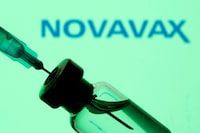 FILE PHOTO: A vial and sryinge are seen in front of a displayed Novavax logo in this illustration taken January 11, 2021. REUTERS/Dado Ruvic/Illustration