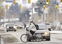 KELOWNA BC - DEC 21/10 - A woman riding a bicycle crosses Richter Street in Kelowna on Tuesday, December 21. Photo by Daniel Hayduk