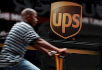 FILE PHOTO: A bicycle delivery man rides past a UPS truck in New York's Times Square, July 23, 2012.  REUTERS/Brendan McDermid (UNITED STATES - Tags: TRANSPORT BUSINESS)/File Photo