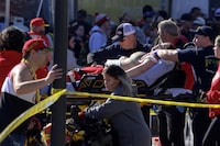 FILE - A woman is rushed to an ambulance following a shooting at the Kansas City Chiefs NFL football Super Bowl celebration in Kansas City, Mo., Wednesday, Feb. 14, 2024. A third man is now facing murder charges for the Feb. 14 shootings during the Kansas City Chiefs' Super Bowl rally. One woman died and about two dozen other people were hurt in the burst of gunfire. (AP Photo/Reed Hoffmann, File)
