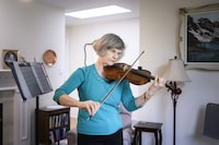 Karen Kristjanson plays the violin at home in Surrey British Columbia on February 21, 2024. (Jennifer Gauthier/The Globe and Mail)



