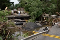 A motorist stops to survey the damage to a washed-out bridge following a major rain event near Newport Corner, N.S. on Sunday, July 23, 2023. Nova Scotia’s Department of Public Works says it’s repaired nearly 500 sections of damaged paved and gravel roads and 60 road shoulders since last weekend's record storm caused severe flooding. THE CANADIAN PRESS/Darren Calabrese