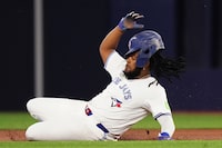 Toronto Blue Jays' Vladimir Guerrero Jr. (27) is forced out at second base on a double play during first inning American League MLB baseball action against the Seattle Mariners in Toronto on Tuesday, April 9, 2024. THE CANADIAN PRESS/Chris Young