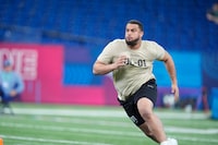 Illinois offensive lineman Isaiah Adams runs a drill at the NFL football scouting combine, Sunday, March 3, 2024, in Indianapolis. (AP Photo/Michael Conroy)